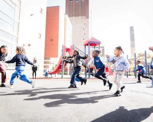 Students running and playing together on the outdoor playground