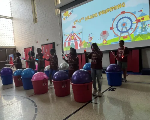 Students drumming together during a grade-school performance